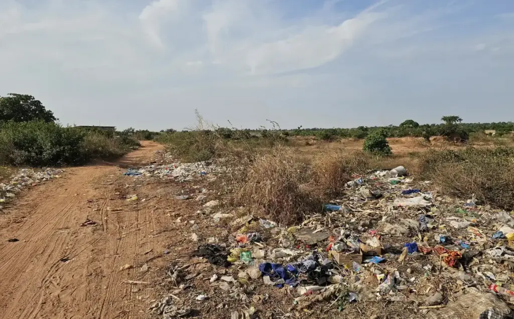 Eine Weg in Banjul mit Plastikmüll links und rechts vom Weg.